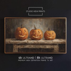 May include: A framed painting featuring three carved pumpkins with smiling faces. The pumpkins are orange and sit on a weathered wooden surface. The artwork is labeled "STUDIO VIEW PRINTS" and "4K ULTRAHD | 8K ULTRAHD PREMIUM HIGH DEFINITION FRAME TV ART".