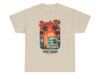 May include: Beige t-shirt featuring a tropical sunset design with palm trees, a surfboard, and the text "Beach Life Tropical Sunset West Coast Since 1999". The graphic is in shades of orange, blue, and green.