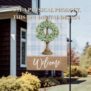 May include: A garden flag with a wreath design on a stand, set against a blue and white plaid background. The flag has a burlap bottom with the word "Welcome" in white script.