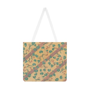 Könnte beinhalten: Tragetasche mit botanischem Muster. Die Tasche hat ein sich wiederholendes Design aus grünen Blättern und roten Akzenten auf beigem Hintergrund, mit diagonalen Streifen in einem dunkleren Farbton. Weiße Träger vervollständigen das Design.