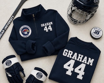 May include: Navy blue hockey gear set, including a helmet, gloves, stick, and apparel with "GRAHAM 44" and "Briar University Hawks" logos. The set is arranged on a light background.