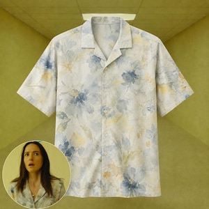 Peut inclure: Une chemise à manches courtes boutonnée avec un motif floral de style aquarelle dans des tons de bleu sourd, de jaune doux et de crème. Le vêtement présente un col classique, une patte de boutonnage avant et une coupe décontractée.