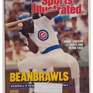 May include: Sports Illustrated magazine cover from July 20, 1987, featuring Andre Dawson of the Chicago Cubs. The cover shows Dawson getting hit in the face by a baseball while batting. The headline reads "BEANBRAWLS".