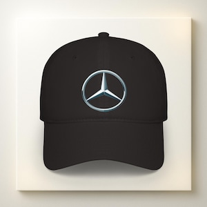 May include: Black baseball cap featuring the Mercedes-Benz logo. The logo is a silver three-pointed star inside a silver circle. The cap has a curved brim and a rounded crown.