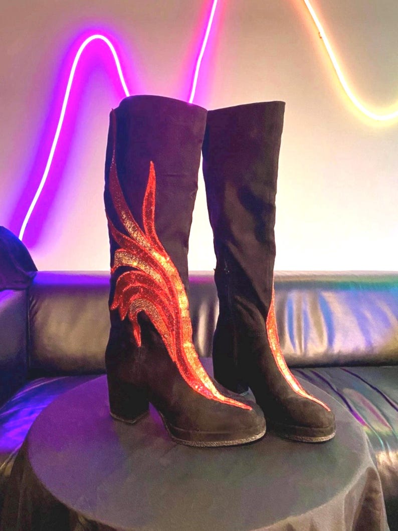 Black faux suede Fireball Flame Boots with red and gold sequin flames designed and created by Niniannebast Designs for Hamilton Fashion Week 2026. Front side view.
