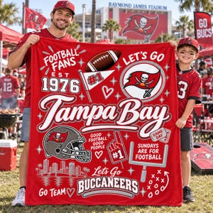 May include: A red fleece blanket featuring Tampa Bay Buccaneers graphics, including a football, a helmet, a foam finger, a goalpost, the text 'Tampa Bay', 'Football Fans Est 1976', 'Let's Go', 'Sundays Are For Football', and 'Let's Go Buccaneers'.