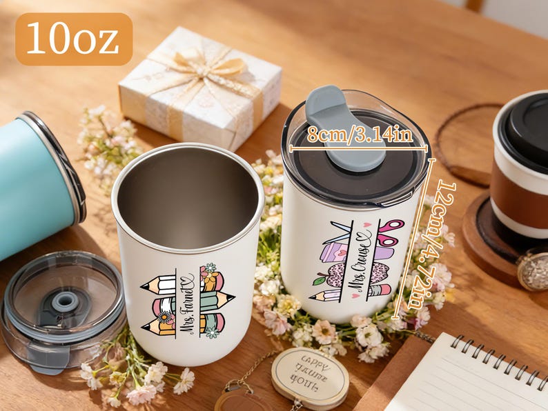 May include: Two white insulated tumblers with black lids, one open and one closed, decorated with teacher-themed graphics. One tumbler is labeled "Mrs. Farnet" and the other "Mrs. Cruse". The tumblers are 4.72 inches tall and 3.14 inches wide.