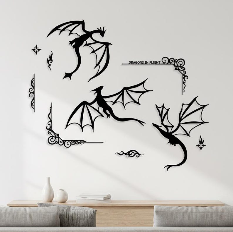 May include: Black dragon wall art in various poses, with outstretched wings, and decorative corner accents. The text "Dragons in Flight" is included. The art is mounted on a white wall above a wooden cabinet.