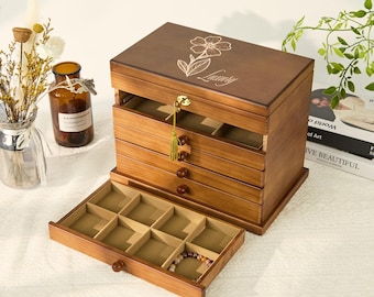 May include: A wooden jewelry box with multiple drawers and a hinged lid. The box is stained a warm brown and features a floral design and the word "Luxury" etched on the lid. The drawers are lined with a beige fabric, and a gold tassel hangs from the lock.