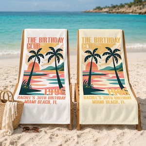 May include: Two beach towels draped over wooden lounge chairs featuring a graphic of palm trees, a sunset, and the text THE BIRTHDAY CLUB 1996 RACHEL'S 30TH BIRTHDAY MIAMI BEACH, FL. The towels display a colorful coastal scene with pink and blue hues.