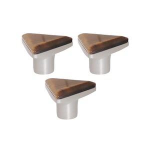 Puede incluir: Tres tiradores de armario con una parte superior triangular con un diseño marrón veteado. Los tiradores tienen una base y un vástago de plata cepillada. Estos tiradores decorativos son adecuados para cajones y armarios.