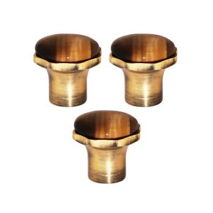 May include: Three cabinet knobs with a tiger's eye stone top and a bronze-coloured base. The knobs have a rounded top and a flared base, suitable for furniture or cabinet hardware.