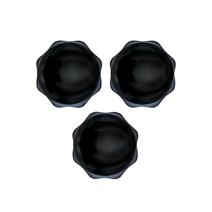 May include: Three black, scalloped-edge bowls are arranged in a triangular pattern against a white background. The bowls have a glossy finish and a dark blue rim, creating a contrast with the black interior.