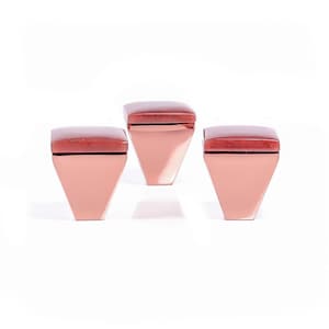 Pode incluir: Três puxadores de armário geométricos. Cada puxador apresenta uma base em forma de diamante em ouro rosa, encimada por um detalhe quadrado marrom avermelhado. Os puxadores são dispostos sobre um fundo branco, mostrando seu design moderno.