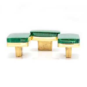 Puede incluir: Juego de tres tiradores de armario. Cada tirador tiene una parte superior cuadrada verde estilo malaquita y una base de metal dorado. El diseño es moderno, adecuado para cajones o puertas de armario.