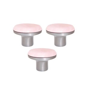 Pode incluir: Três puxadores de armário com um topo oval rosa claro e uma base prateada. Os puxadores têm um design moderno e minimalista e estão sobre um fundo branco. Adequados para gavetas e armários.