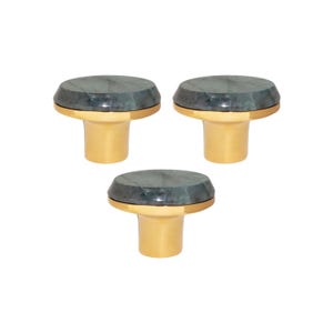 May include: Three bottle stoppers with a dark green, faceted top and a gold-coloured base. The stoppers are arranged in a triangular pattern. The background is white.