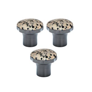 Könnte beinhalten: Drei Schrankknöpfe mit einer gesprenkelten, cremefarbenen Oberseite und einem dunkelgrauen Sockel. Die Knöpfe haben eine abgerundete Oberseite und einen zylindrischen Sockel, geeignet für Möbel oder Dekoration.