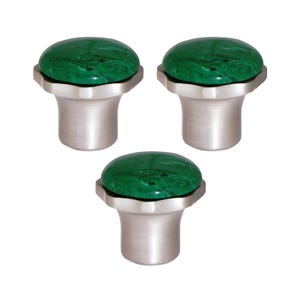 May include: Three cabinet knobs with a brushed silver finish and a round, green, marbled stone top. The knobs have a decorative, octagonal base. Suitable for drawers, cabinets, or furniture. Each knob is approximately 3 cm in diameter.