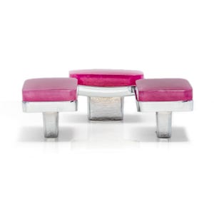 Op de afbeelding: Driedelige set kastknoppen met een modern design. Elke knop heeft een vierkante, magenta gekleurde bovenkant en een zilverkleurige, rechthoekige basis. De knoppen staan tegen een witte achtergrond.