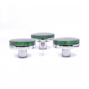 Könnte beinhalten: Drei dekorative Schrankknöpfe mit einer kreisförmigen grünen Oberseite und einem polierten Chromsockel. Die Knöpfe sind in einer Reihe vor einem weißen Hintergrund angeordnet. Die grünen Oberteile haben ein marmoriertes Aussehen.