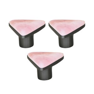 Pode incluir: Três puxadores de armário com formato triangular e design rosa marmorizado. Os puxadores têm uma borda preta e uma haste cinza escuro. Estes puxadores decorativos são adequados para gavetas e armários.