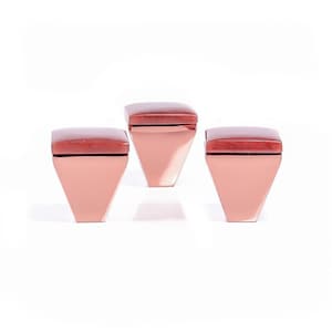 Può includere: Tre scatole decorative geometriche. Ogni scatola ha una base a forma di trapezio color rame e un top quadrato marrone scuro. Le scatole sono disposte a triangolo su sfondo bianco.