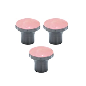 Pode incluir: Três puxadores de armário com um topo arredondado rosa claro e uma base cilíndrica cinza escuro. Os puxadores têm um design moderno e minimalista, adequados para gavetas ou portas de armário. Os puxadores são mostrados em um fundo branco.