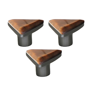 Könnte beinhalten: Drei Schrankknöpfe mit dreieckiger Oberseite mit einem Holzmaserungsmuster in Braun- und Bernsteintönen. Der Sockel jedes Knopfes ist dunkelgrau. Diese Knöpfe eignen sich für Möbel und Heimdekoration.