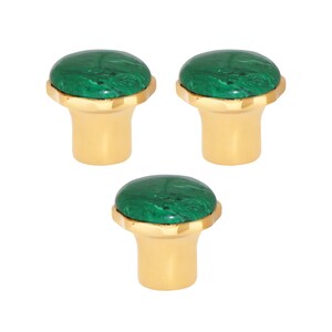 May include: Three cabinet knobs with a gold-coloured base and a green, marbled stone top. The knobs have a classic design, suitable for furniture or cabinetry. The green stone has a unique pattern.