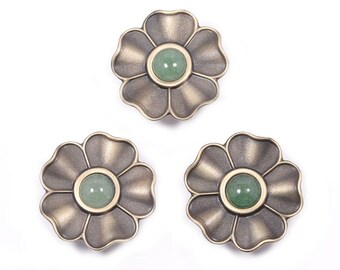 May include: Three flower-shaped decorative knobs. Each knob has a bronze-colored metal finish with a green gemstone center. The knobs are arranged on a white background. These knobs are suitable for furniture or craft projects.