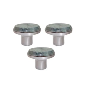 Può includere: Tre pomelli per mobili con base argentata e piano rotondo in marmo verde. I pomelli sono disposti a triangolo su sfondo bianco. Il marmo ha un aspetto venato naturale.