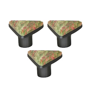 Könnte beinhalten: Drei Schrankknöpfe mit einer dreieckigen Oberseite mit einem grünen, roten und braunen Muster und einem dunkelgrauen zylindrischen Sockel. Die Knöpfe sind für Möbel und Heimdekoration konzipiert.