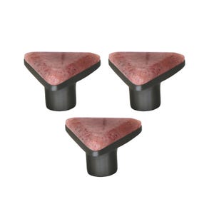 Könnte beinhalten: Drei Schrankknöpfe mit einer dreieckigen, gesprenkelten, rötlich-braunen Oberseite und einem dunkelgrauen zylindrischen Sockel. Die Knöpfe sind vor einem weißen Hintergrund angeordnet.