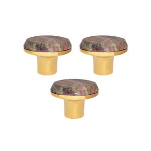 Può includere: Tre tappi decorativi per bottiglie. Ogni tappo ha una base dorata e una parte superiore marmorizzata nei toni del rosa, marrone e grigio. Questi tappi sono progettati per bottiglie di vino. Altezza: circa 5 cm.