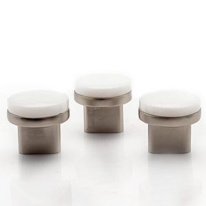 May include: Three cabinet knobs with a white, circular top and a brushed nickel base. The knobs have a modern design and are suitable for drawers or cabinet doors. The knobs are displayed against a white background.