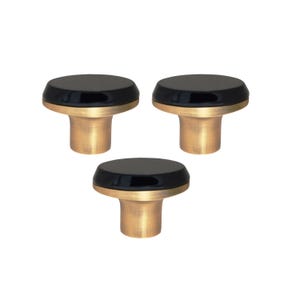 以下が含まれることがあります： 黒い円形のトップと金色の円筒形のベースを備えた3つのキャビネットノブ。ノブは白い背景に対して三角形のパターンで配置されています。これらの装飾的なノブは家具に適しています。