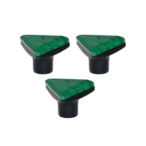 Puede incluir: Tres tiradores decorativos para armarios. Cada tirador presenta una parte superior triangular con un patrón verde veteado y una base negra. Los tiradores están sobre un fondo blanco.