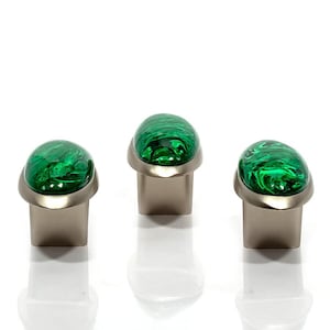 May include: Three cabinet knobs. Each has a silver-tone base and a green, marbled glass top. The knobs are arranged in a row against a white background, with their reflections visible below.