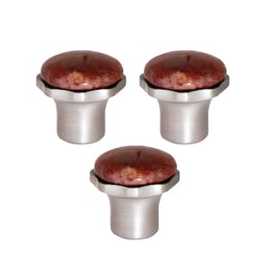 Może przedstawiać: Trzy gałki do szafek z podstawą ze szczotkowanego srebra i okrągłym, czerwonobrązowym kamiennym blatem. Gałki mają nowoczesny design. Kamienne blaty mają nakrapiany wygląd. Białe tło.