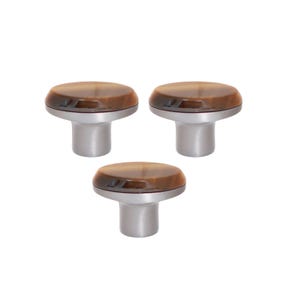 May include: Three cabinet knobs with a brushed silver base and a brown, marbled top. The knobs have a rounded, oval shape and are evenly spaced against a white background. These decorative knobs are suitable for furniture and home decor.