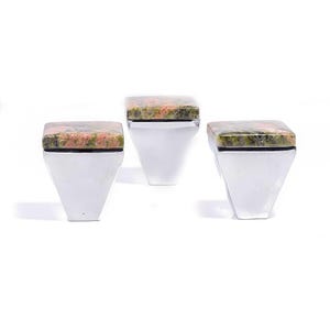 Könnte beinhalten: Drei dekorative Schrankknöpfe. Jeder Knopf hat eine quadratische, gesprenkelte, rosa-grüne Steinplatte, die auf einer polierten, silberfarbenen, trapezförmigen Basis angebracht ist. Die Knöpfe werden vor einem weißen Hintergrund präsentiert.