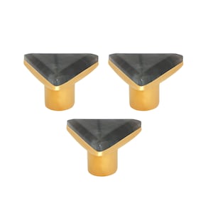Könnte beinhalten: Drei Schrankknöpfe mit einer dreieckigen, dunkelgrauen Steinplatte und einem goldfarbenen Sockel. Die Knöpfe sind in einem Dreiecksmuster vor einem weißen Hintergrund angeordnet. Diese dekorativen Knöpfe sind für Möbel geeignet.