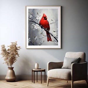 May include: A framed art print featuring a vibrant red cardinal perched on a branch with white blossoms. The artwork is set against a soft, gray background, creating a serene and natural scene. The print is displayed in a living room setting.
