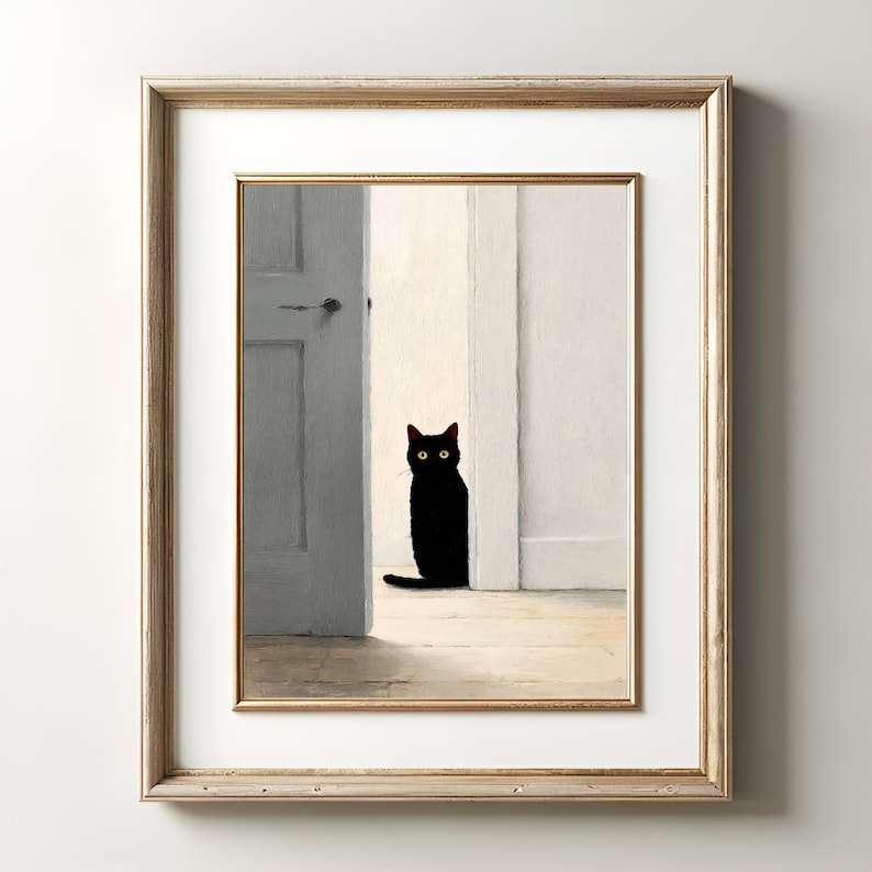 Peut inclure: Impression d'art encadr&eacute;e repr&eacute;sentant un chat noir aux yeux jaunes, assis dans une embrasure de porte. La sc&egrave;ne se d&eacute;roule dans une pi&egrave;ce aux murs blancs et au sol en bois clair. Le cadre est de couleur or clair.