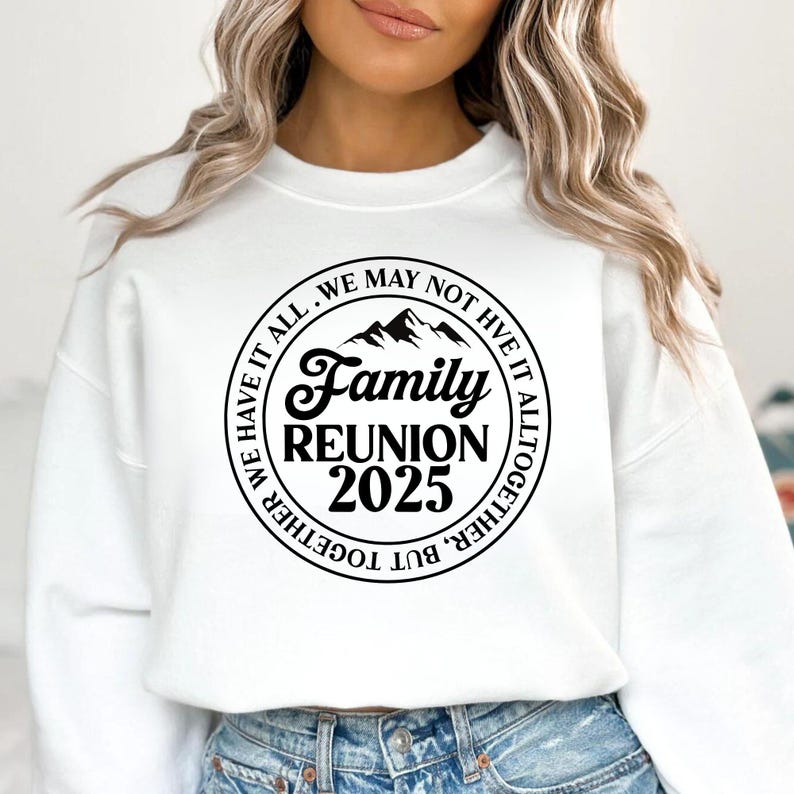 Pu&ograve; includere: Felpa bianca con grafica circolare nera con la scritta "Family Reunion 2025". La grafica include sagome di montagne e il testo "We may not have it all, but together we have it all together."