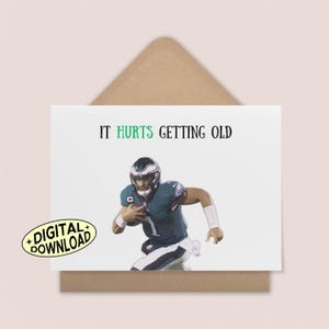 Może przedstawiać: Biała kartka z pozdrowieniami z napisem "IT HURTS GETTING OLD" i ilustracją gracza w futbol amerykański. Karta posiada naklejkę do pobrania cyfrowego. Karta umieszczona jest na brązowej kopercie.