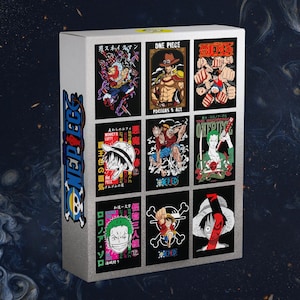 May include: A white box featuring nine colorful One Piece character art prints. The prints showcase various characters in action poses, with Japanese text and the One Piece logo. The box has the One Piece logo on the side.
