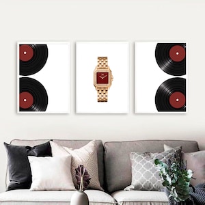 Puede incluir: Un conjunto de tres cuadros de pared que presenta dos impresiones de discos de vinilo negros con centros rojos en los paneles exteriores y una impresión central de un reloj de pulsera dorado con esfera cuadrada roja y brazalete.