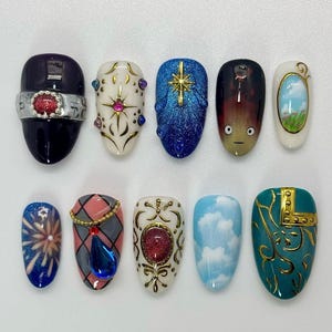 Peut inclure: Dix faux ongles aux motifs vari&eacute;s. On y trouve un ongle violet fonc&eacute; avec une bande argent&eacute;e et une gemme rouge, un ongle blanc avec des accents dor&eacute;s et une gemme rose, et un ongle bleu avec une &eacute;toile dor&eacute;e. Chaque ongle est unique.